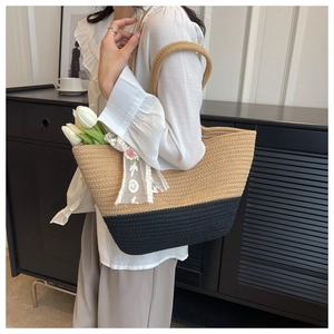 Detail of large woven beach tote bag with contrasting colors and lace ribbon trim