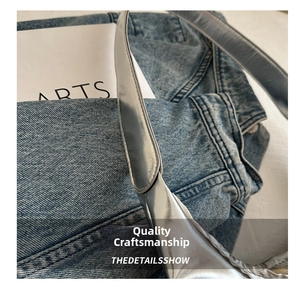 Close-up of metallic silver strap with mirror finish on blue denim fabric background