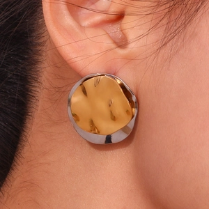 Minimalist bicolor irregular round stud earrings in 18K gold and silver finish on ear