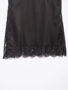Détail de tissu en satin noir avec bordure en dentelle complexe sur un caraco élégant
