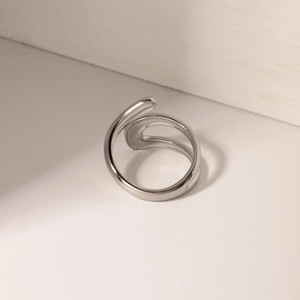 Macro shot of a silver crossover open ring with a polished minimalist stainless steel finish