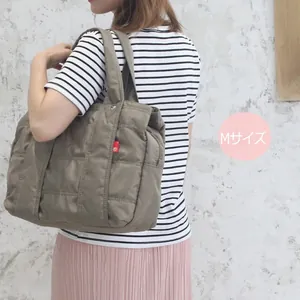 Quilted nylon tote bag in brownish grey M size shown worn on shoulder for travel