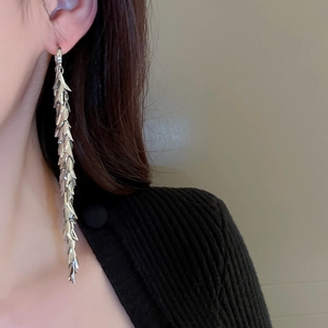 Detailed view of silver leaf tassel earrings on model showing metal layered fringe