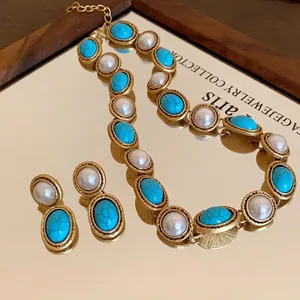 Retro jewelry set with oval turquoise and faux pearls in gold finish on a mirror base