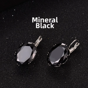 Macro view of oval-cut mineral black stone earrings with silver lever-back settings