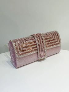 Detail shot of a pink evening clutch with sparkling crystal patterns and metallic clasp