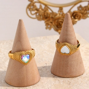 Close-up of 18K gold braided rings featuring rainbow and mother-of-pearl heart zircons