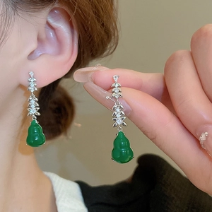 Detailed view of green gourd drop earrings with gold inlay and pavé diamond accents