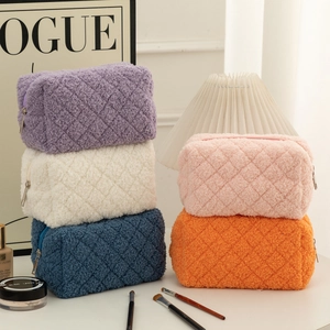 Detailed close-up of quilted fleece pencil cases in five pastel colors with metal zippers
