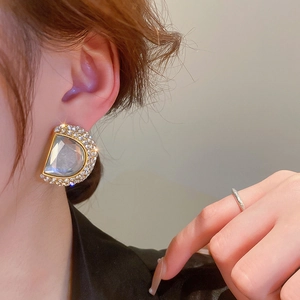 Gros plan détaillé des boucles d'oreilles en strass en D avec pierre grise