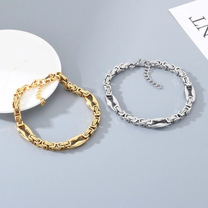 Détail macro des bracelets chaîne à lèvres en acier doré et argenté avec maillons groin