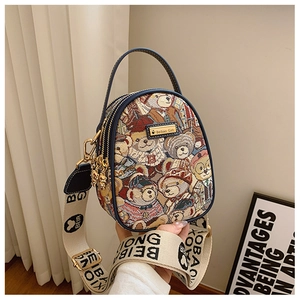 Detail of embroidered teddy bear patterns and metal logo plate on this versatile crossbody bag