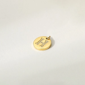 Polished 14K gold plated stainless steel round pendant with sparkling crystal H letter inlay