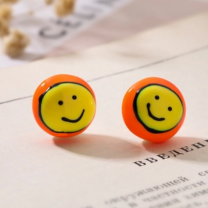 Boucles d'oreilles dorées avec visage souriant en émail orange et détails de perles