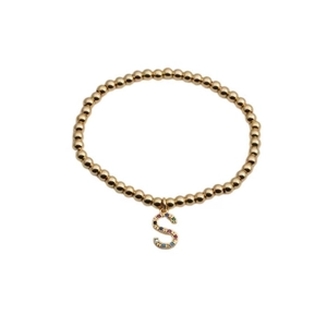 Gold beaded stretch bracelet featuring a colorful cubic zirconia letter S charm pendant