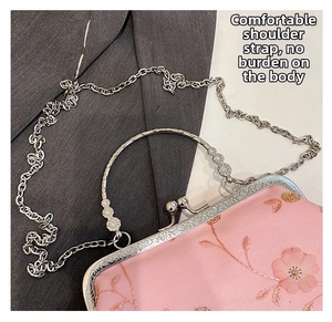 Detail of pink floral embroidery on mesh fabric with vintage silver clasp and chain