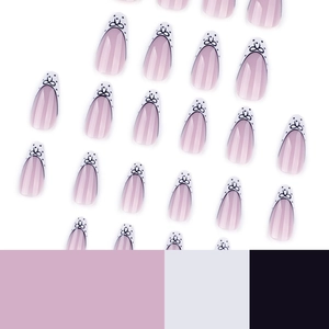 French almond press-on nails with white tips, pink base and black bow dot patterns