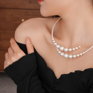 Detail of irregular pearl choker with gold beads on neck for elegant French vintage look