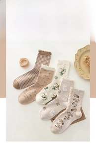 Detailed flat lay of five cotton mid-calf socks with rabbit embroidery and floral patterns