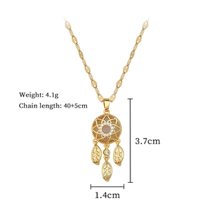 Detail of gold dreamcatcher pendant with central gemstone and feather leaf charms