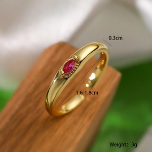 Macro view of gold plated adjustable ring with red zircon inlay and size details