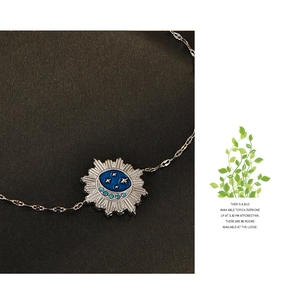 Macro shot of silver link bracelet featuring blue enamel sun moon and star charms
