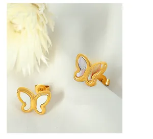 Detail of 18k gold butterfly stud earrings with iridescent mother of pearl on white fabric