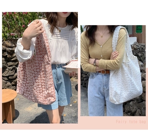 Detail of pink and white floral lace tote bags with delicate embroidery and long shoulder straps