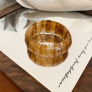 Close-up of amber resin stretch bracelet with marble texture and smooth rectangular beads