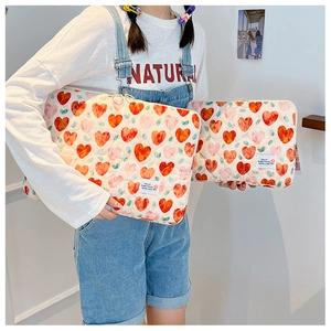 Detailed set of two quilted heart pattern laptop sleeves held by a model in a bright room