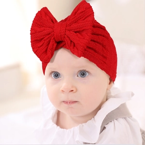 Gros plan du bandeau pour bébé avec un grand nœud rouge et texture en maille