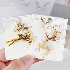 Detail of Christmas reindeer brooches with enamel, rhinestones and pearls on display card