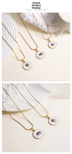 Detail of gold evil eye pendants with hand, elephant and star motifs on snake chains