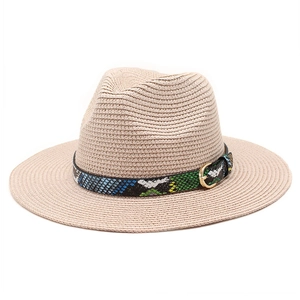 Detail of light khaki straw sun hat featuring a colorful snake print band and gold buckle