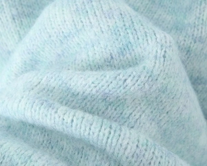 Close-up of light blue mohair knit texture showing soft fuzzy fibers and dense weave