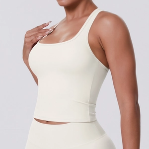 Detail of a beige racerback yoga tank top showing elastic quick-dry fabric texture on model