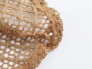 Close-up of brown crochet fabric detail with hexagonal mesh pattern for beach sets
