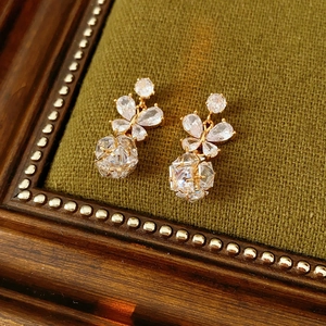 Détail de boucles d'oreilles papillon dorées sur fond vintage en velours olive