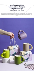 Macro shot of colorful ceramic mugs with unique ball handles and matte texture finish