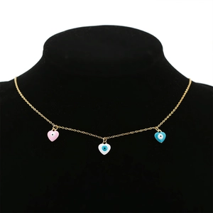 Close-up of pink, white, and blue heart-shaped evil eye pendants on a gold necklace