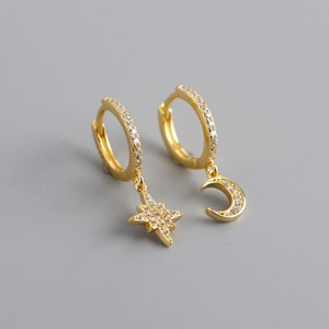 Macro shot of asymmetric gold star and moon earrings with sparkling micro-pave zircons