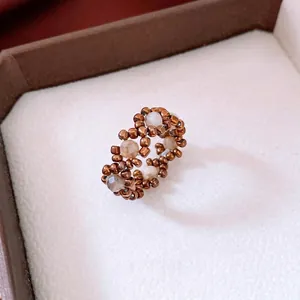 Vintage beaded stretch ring with bronze and translucent white seeds in a diamond grid