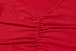 Close-up of red off-shoulder dress featuring V-neckline and elegant ruched fabric detail