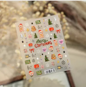 Macro shot of cute Christmas nail stickers featuring hand-drawn bears and festive trees