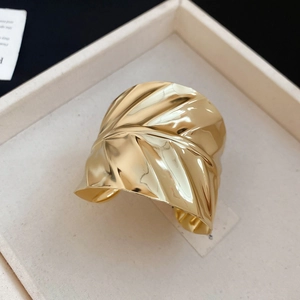 Vue détaillée de la texture ondulée dorée irrégulière sur un bracelet jonc ouvert chic