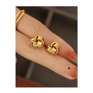 Boucles d'oreilles nœuds torsadés dorés minimalistes présentées à la main, style rétro