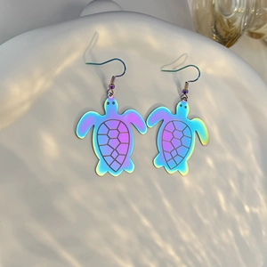 Macro detail of iridescent sea turtle earrings with rainbow metallic finish and carved shells
