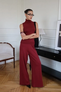 Detail of burgundy turtleneck sleeveless knit top and wide leg pants set for women