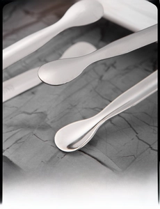 Macro shot of 11cm stainless steel ice tongs with a textured round head on a stone background