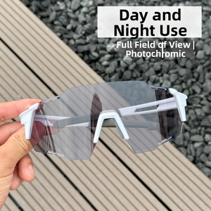 Detail of photochromic cycling sunglasses with white frame held outdoors for sports